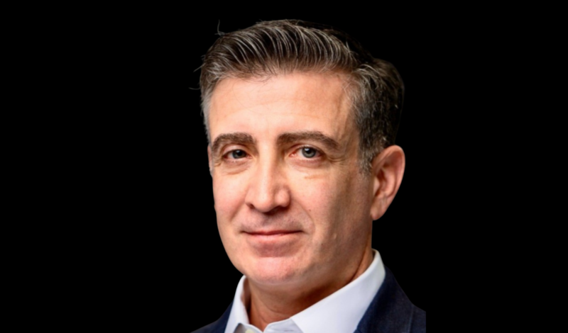 Headshot of Dr. Drew Moghanaki with a dark background
